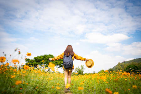 Asian woman tourists is happily running on a flower field.の写真素材