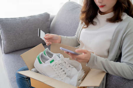 Young woman received a parcel box for shopping online by paying by credit card.の写真素材