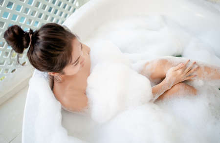Asian woman taking a bath in the bathroom. She is relaxed.の写真素材