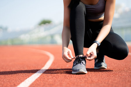 Asian woman tying her shoes for an outdoor run.の写真素材