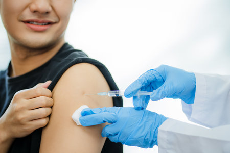 Close-up shot of Asian doctor giving a person a covid-19 vaccine.
He is treating a patient from the covid-19 virus. Health and medical concepts.の写真素材