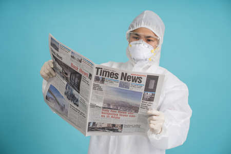 Nakhon Pathom, Thailand - 12 July 2021 : Asian doctor or nurse reading a newspaper. She updated the situation of the new epidemic, Corona-19. rapid epidemic.の写真素材