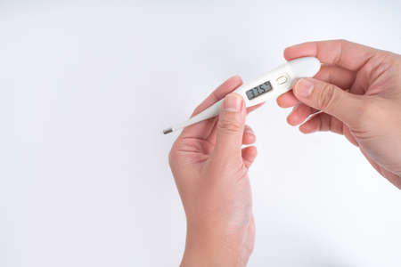 Holding a thermometer on a white background, isolated background.の写真素材