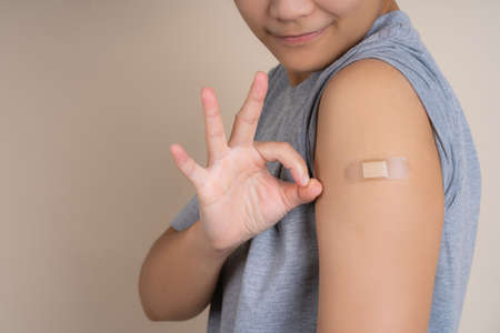 Teenage Asian happily after getting his first vaccine shot, campaign vaccination safe life.