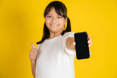 Awesome development educational application or website. Cute girl showing blank cellphone screen.の写真素材