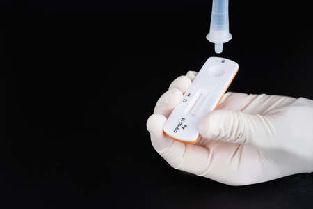 Close up of fingers holding express antigen covid test. Covid-19 Antigen rapid test.