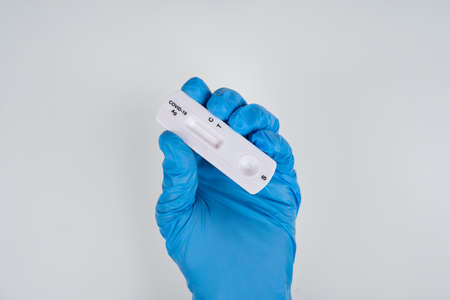 Doctor hand with blue glove holding Rapid antigen test Rapid Strep Test RST kit, COVID-19 virus...