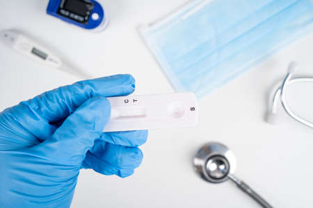 Lab performing rapid diagnostic test for antibodies to detect presence of antigens COVID-19 disease.の写真素材