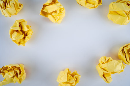 Crumpled yellow paper ball on white background. Flat lay design. Creativity inspiration.の写真素材