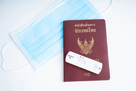 Nakhon Pathom, Thailand - 23 August 2021: Top view of anti virus mask, passport and Rapid antigen test Test RST kit on blue background.のeditorial素材
