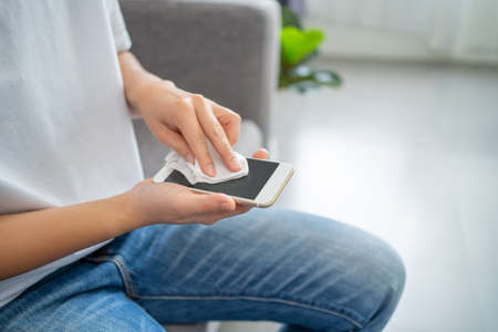 Cleaning Mobile Phones for Covid-19 disease prevention. alcohol, disinfectant on Wipes of Smart Phone for safety.の写真素材