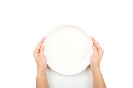 Woman holding empty plate waiting for food, isolated on white background, top view, copy spaceの写真素材