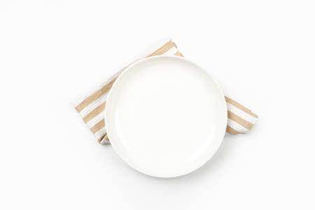 Empty white circle plate on wooden table with linen napkin. Overhead view.の写真素材