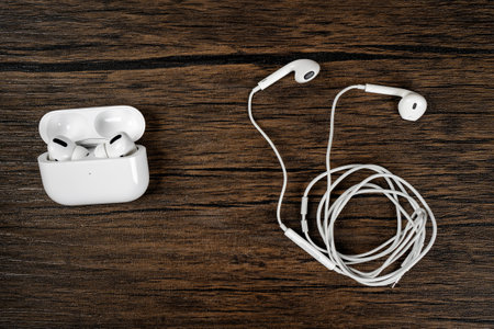 Close-up of white wired headphones and wireless headphones with case connection to smartphone accessories.の写真素材