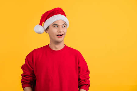 Asian handsome man shocked, surprised, stupefied. Santa Claus man wears Christmas hat sweater posing...