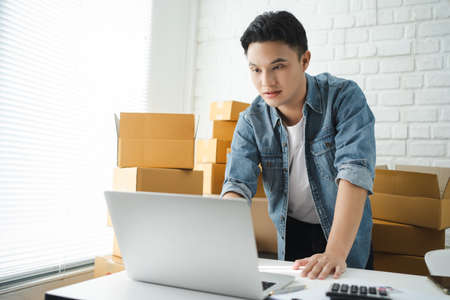 Startup small business owner working with computer at workplace. Freelance man seller check product...