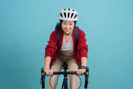 Asian beautiful woman is riding a city bike to workの写真素材