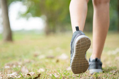Closeup of running shoe of the person running in the nature with beautiful sunlight.