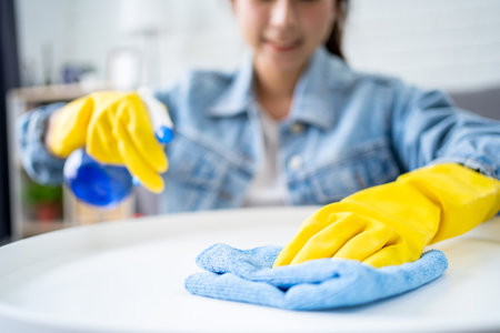 Beautiful young Asian woman cleaning house with microfiber rag. Housekeeping concept.の写真素材