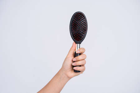 Close up of girl holding wooden hairbrush on white background.の写真素材