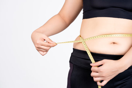 Overweight woman measuring her stomach isolated on white background.