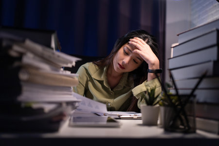 Woman working overtime on a desk at night.