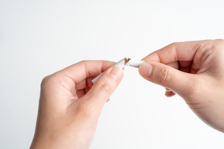 Hands breaking cigarettes on World No Tobacco Day. Stop smoking now on white background.の写真素材