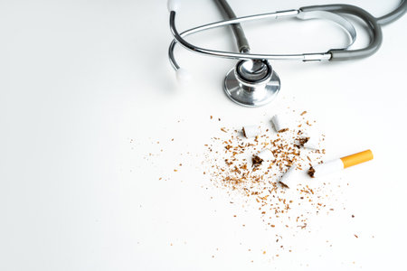 Cigarette with stethoscope on white background with copy space. The drug is harmful to the respiratory system.の写真素材