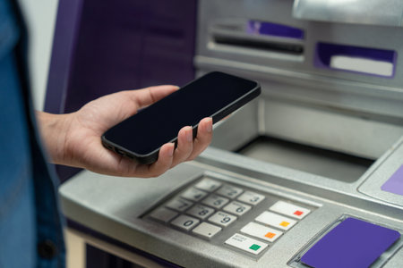 Woman holding a Smartphone financial transactions online on the background, ATM cabinet. Online NFC...