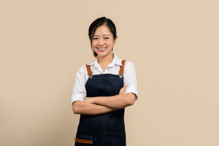 Start a small business. Happy young asian businesswoman wearing white shirt and apron.の写真素材