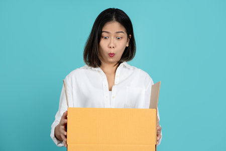 Young excited beautiful asian woman of parcel box receive from the delivery serviceの写真素材