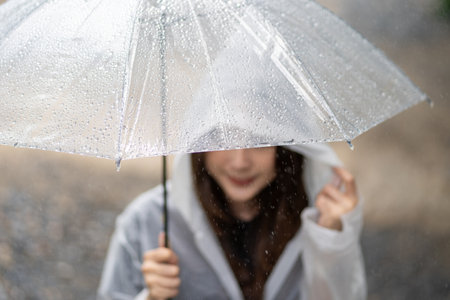 Close-up shot of raindrops on an umbrella in the rain.