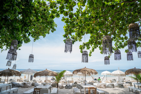 Beachside tables and chairs set for sunbathing in the resortの写真素材