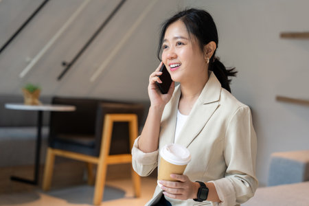 Female freelancer smiling and having fun working with smartphone and tablet at coffee shopの写真素材