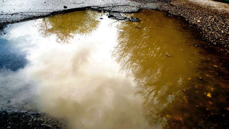 Hole with river water with reflection of trees and skyの写真素材