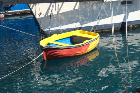 small yellow-orange-blue wooden boatの写真素材