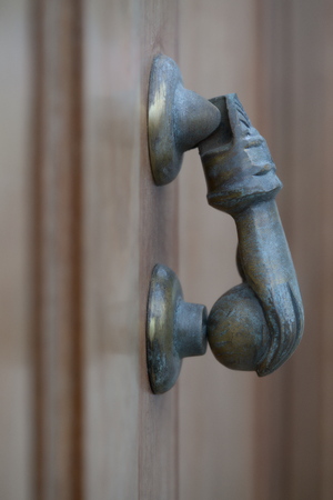 Closeup of a hand as a bronze door knockerの写真素材