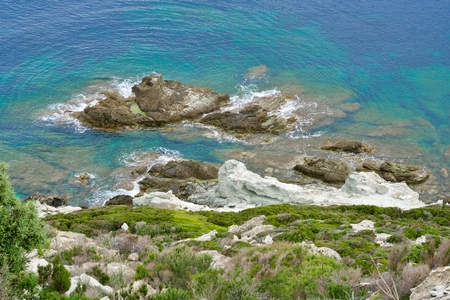 green riff in front of a green-turquois sea with rocks in the waterの写真素材