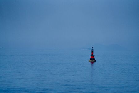 red-black buoy in the blue seaの写真素材