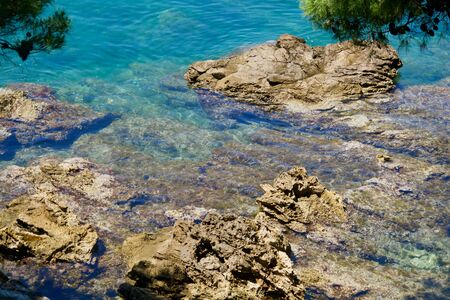close-up of turquoise clean water between beige stonesの写真素材