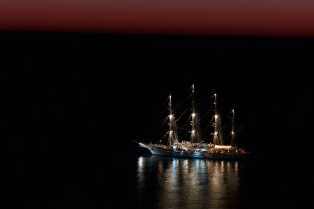 illuminated four-master in the dawn on the black oceanの写真素材