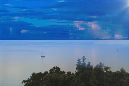 Lonely boat on the sea under a blue dawn skyの写真素材