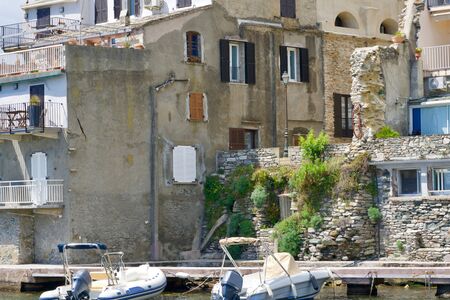 Two sport boats in front of morbid houses