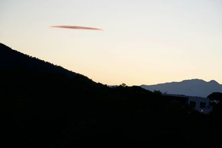 Background of mountains under a red sunset cloudの写真素材