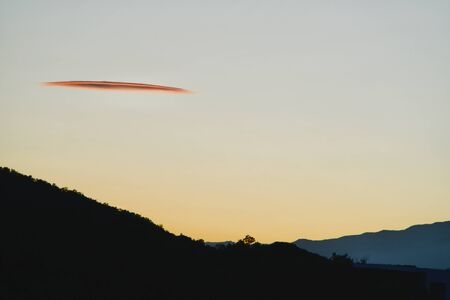 Red cloud above greened mountainsの写真素材