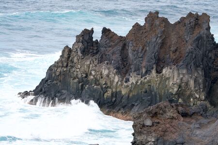 brown rock in the turoquois oceanの写真素材