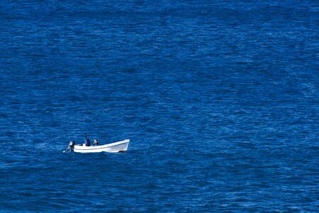White fishing boat on the blue sea