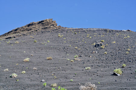 Black lava of a volcano under a perfect blue skyの写真素材