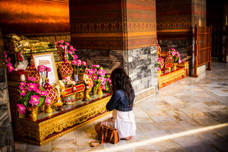 Woman that pay homage to Buddha image in  Wat Pho, Bangkok, Thailandのeditorial素材