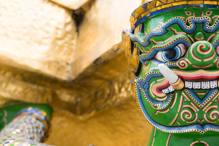 The face beautiful of  giants  statue under golden pagoda in Thailand of the Emerald Buddha temple(Wat phra kaew) and Royal Grand Palace ,Bangkok,Thailandの写真素材